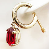 Alexander McQueen gold tone hoop singular earring with ruby red crystal drop. 